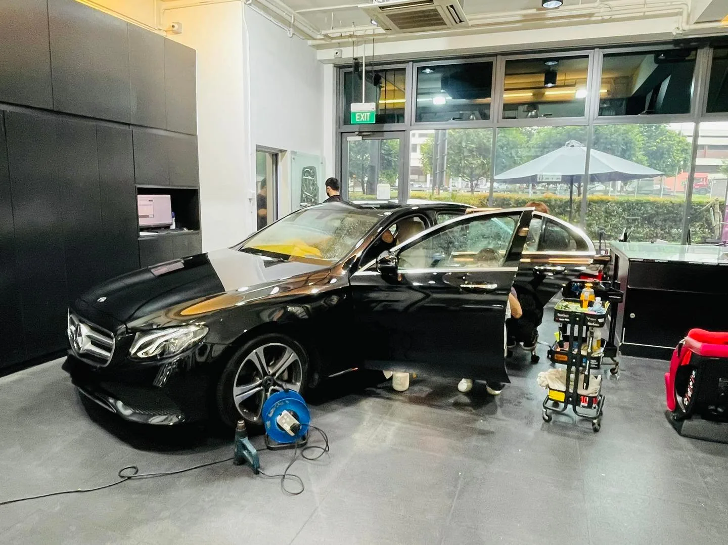 Black Mercedes-Benz E-Class side view during window film install at Infratint Singapore