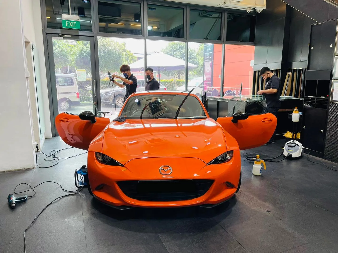 Orange Mazda MX-5 roadster with doors open for window tinting at Infratint Singapore