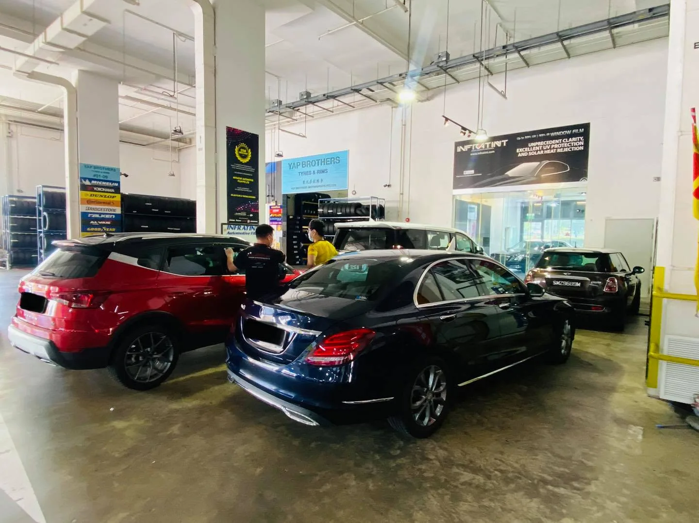 Red SUV, blue Mercedes-Benz C-Class and Mini Cooper at Infratint Singapore window tinting bay