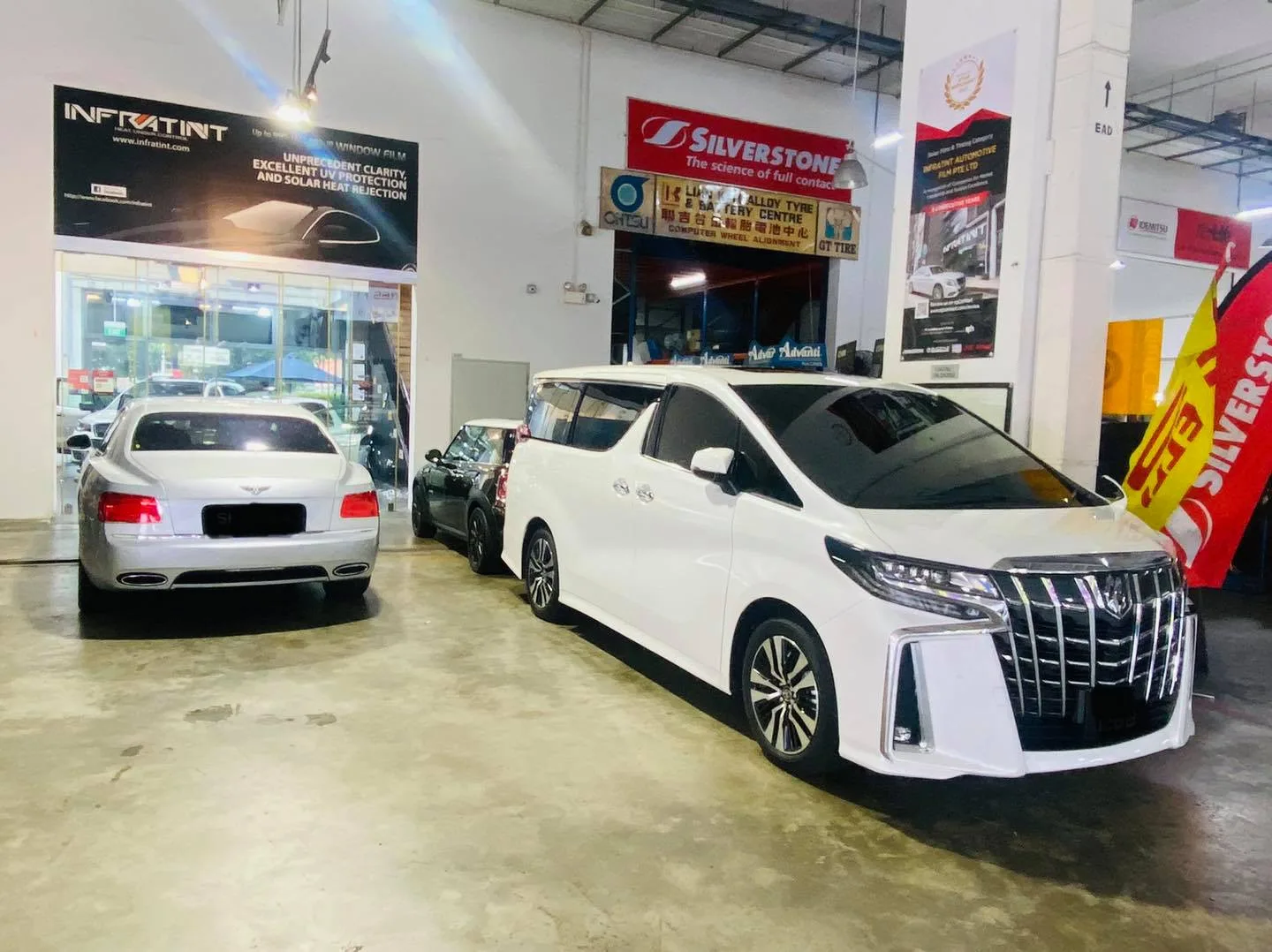 Silver Honda sedan and white Toyota Alphard at Infratint Singapore for window tinting