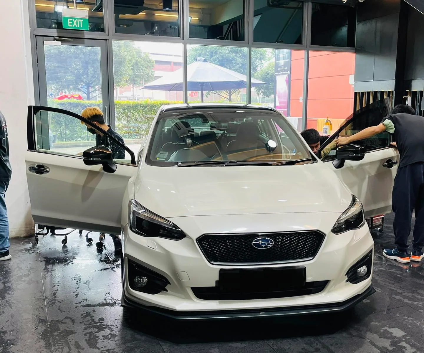 White Subaru Impreza front view during window film installation at Infratint Singapore