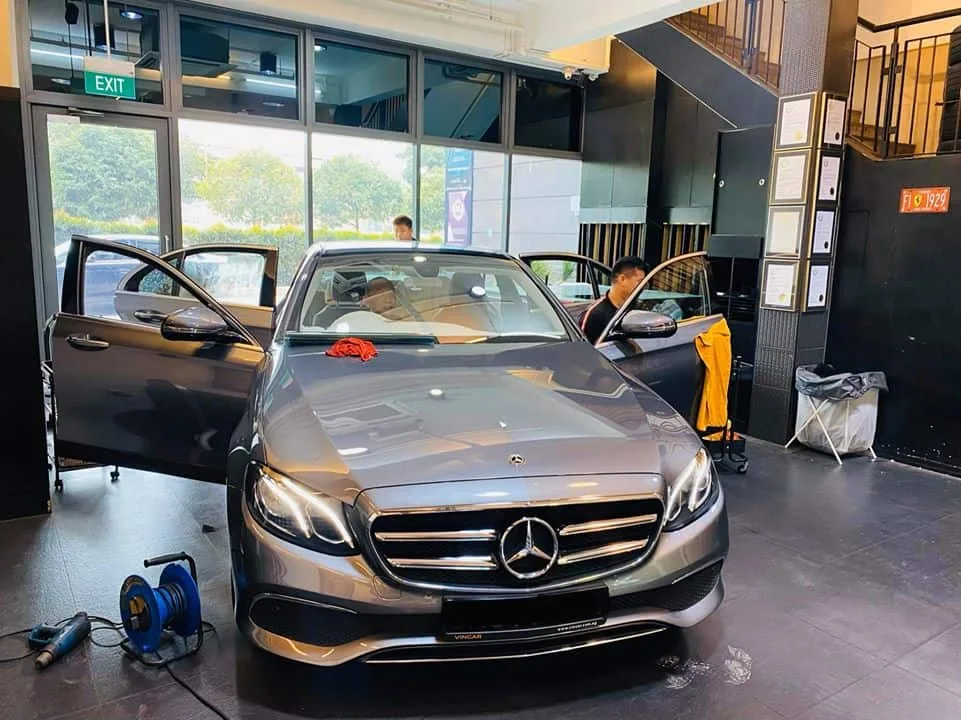 Graphite Mercedes-Benz E-Class with doors open during window tinting at Infratint Singapore