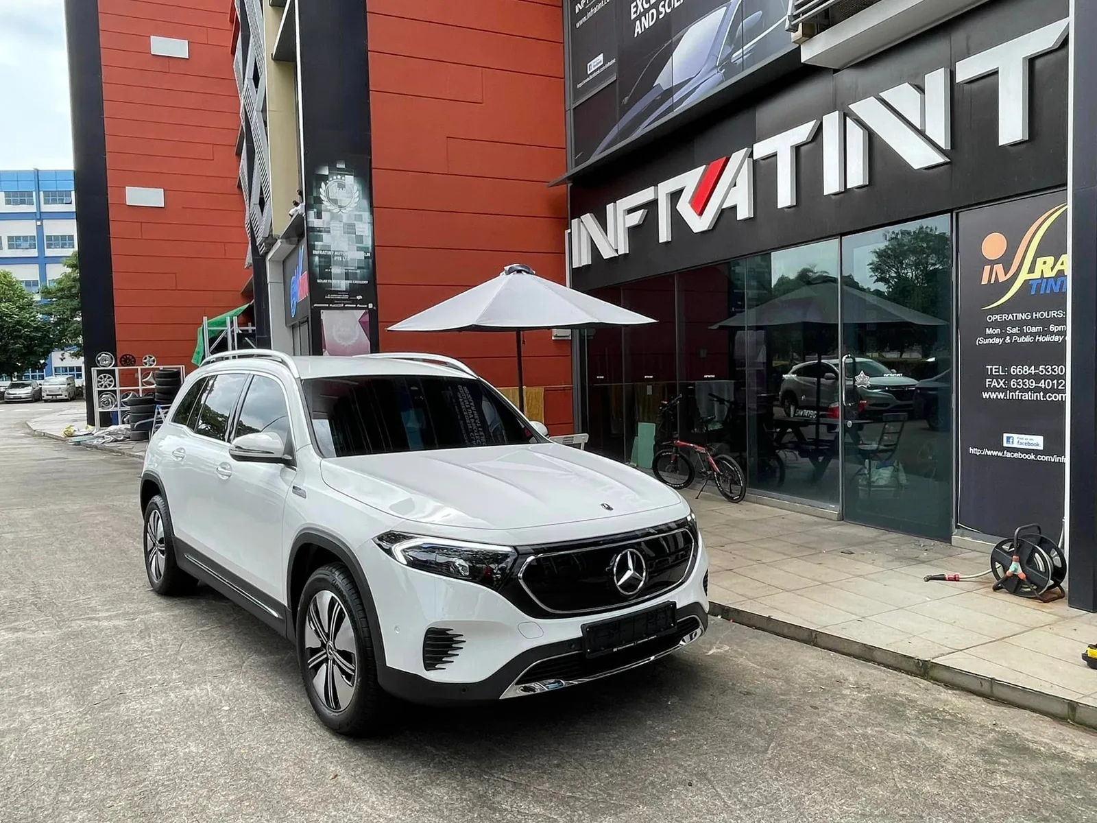 White Mercedes-Benz EQB parked outside the Infratint Singapore shopfront after tinting