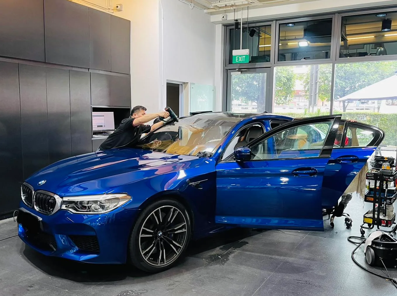 Blue BMW M-Sport sedan front three-quarter during window tinting at Infratint Singapore