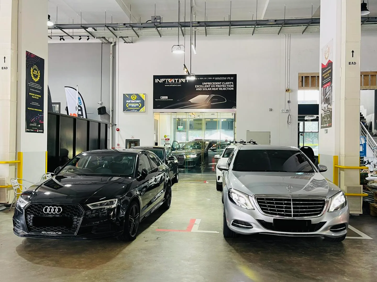Black Audi sedan and silver Mercedes-Benz S-Class inside the Infratint Singapore workshop