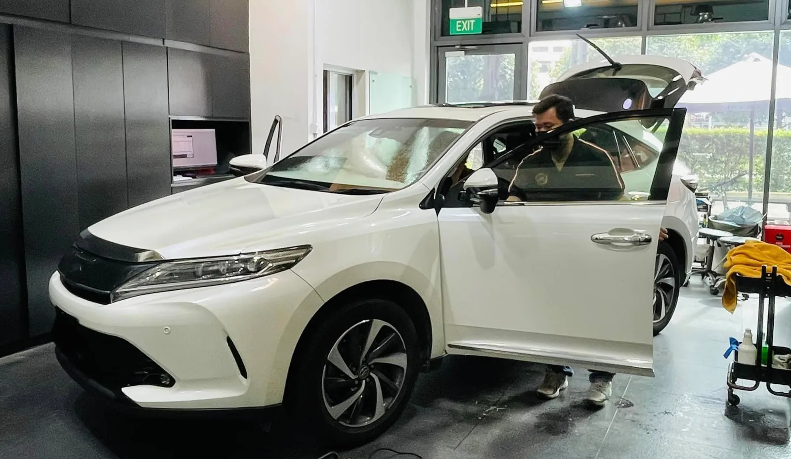 Installer fitting window film to a white Toyota Harrier at Infratint Singapore