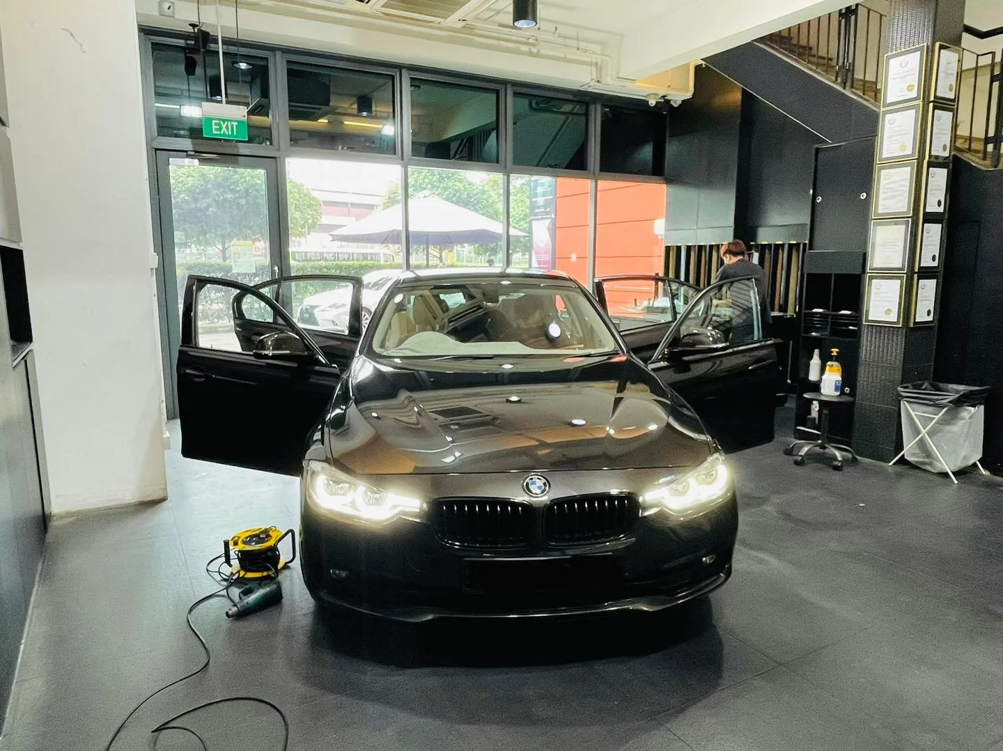 Black BMW sedan with doors open during window tinting at Infratint Singapore