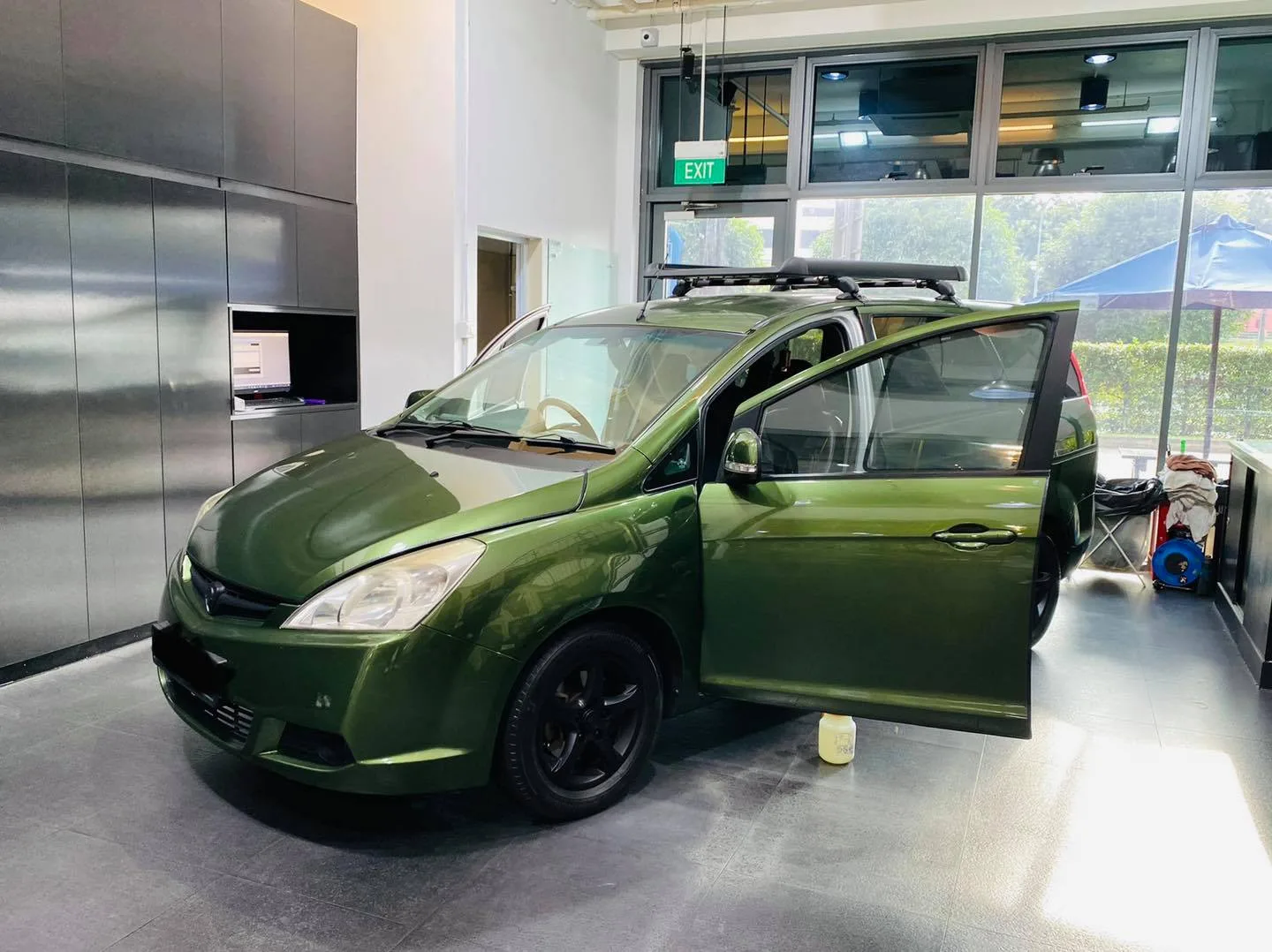 Green Honda MPV during window tinting at Infratint Singapore