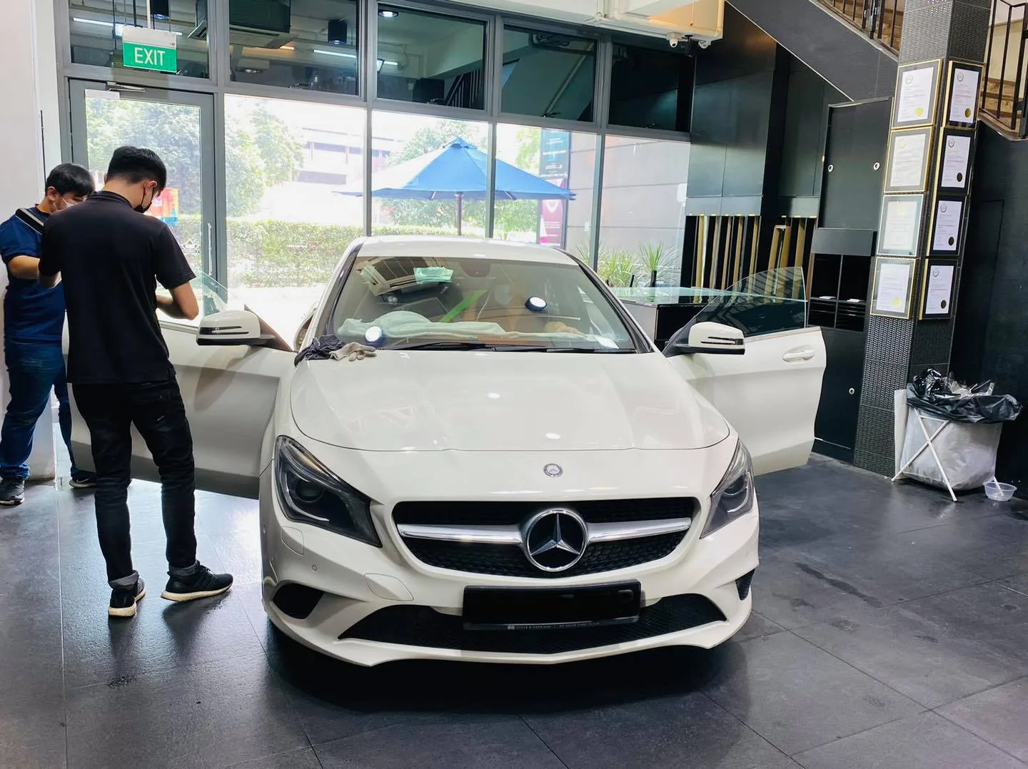White Mercedes-Benz sedan being tinted by two technicians at Infratint Singapore