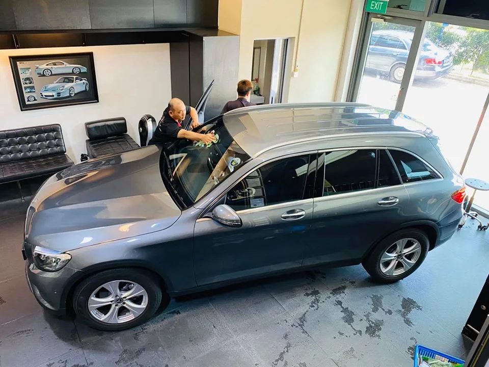 Installer applying film to a grey Mercedes-Benz GLC at Infratint Singapore