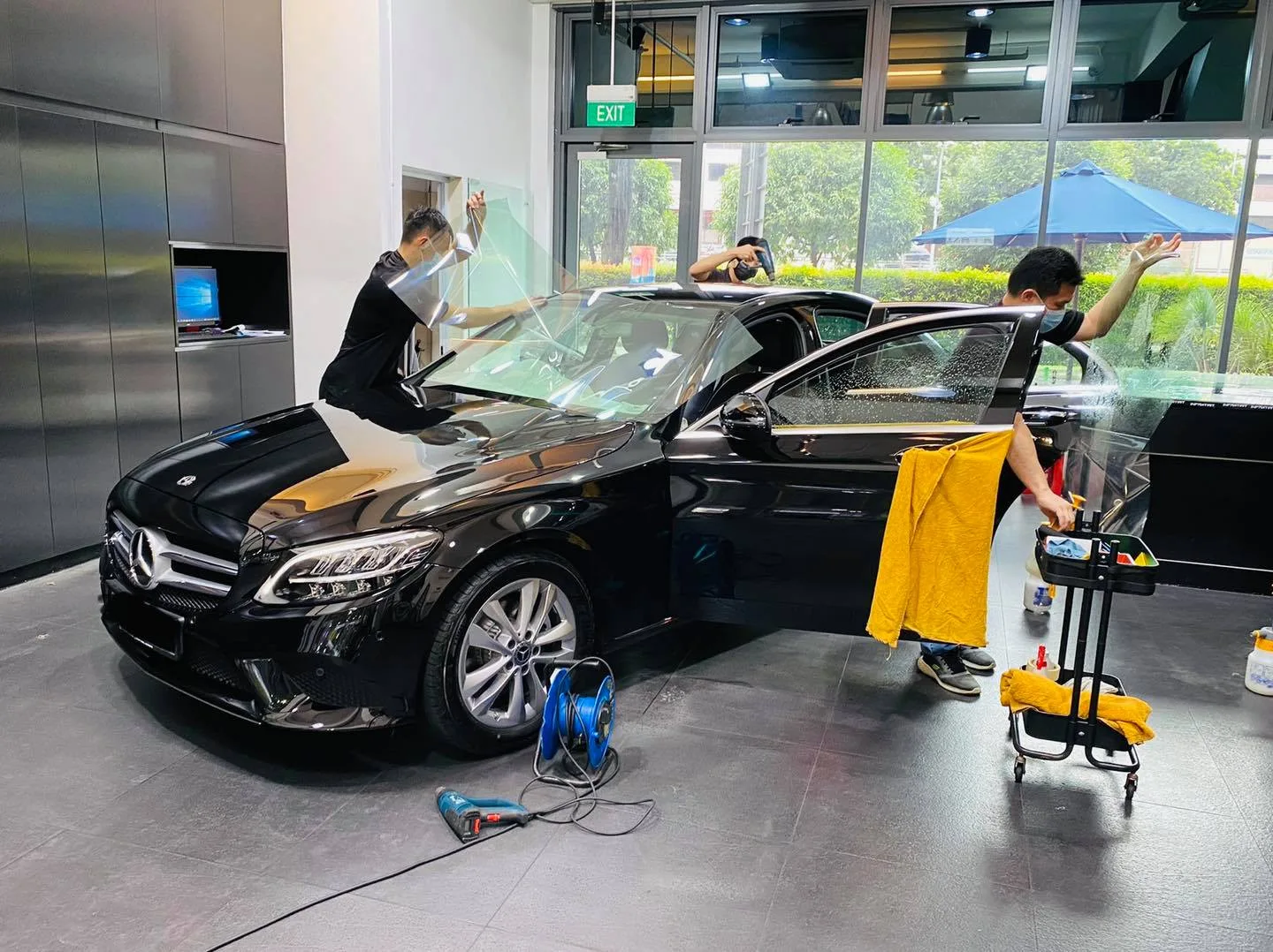 Black Mercedes-Benz C-Class with installers fitting windscreen film at Infratint Singapore