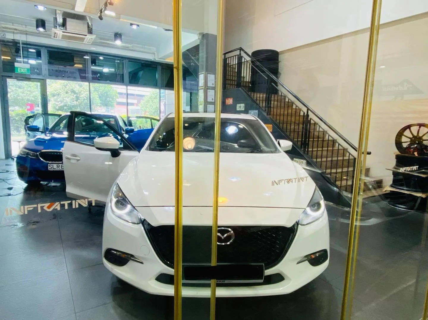 White Mazda 3 and blue BMW 3 Series at Infratint Singapore for window tinting