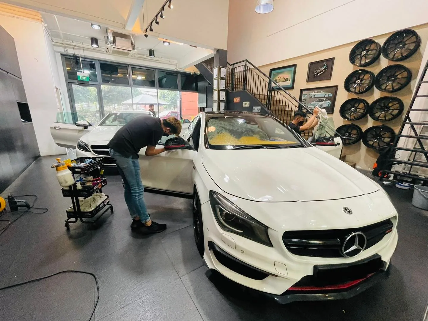 Installer tinting a white Mercedes-Benz CLA at Infratint Singapore