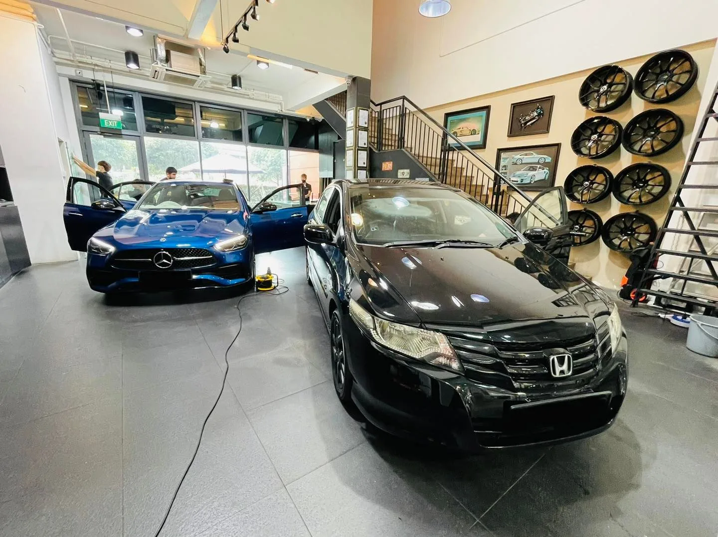 Blue Mercedes-Benz and black Honda sedan in the Infratint Singapore showroom