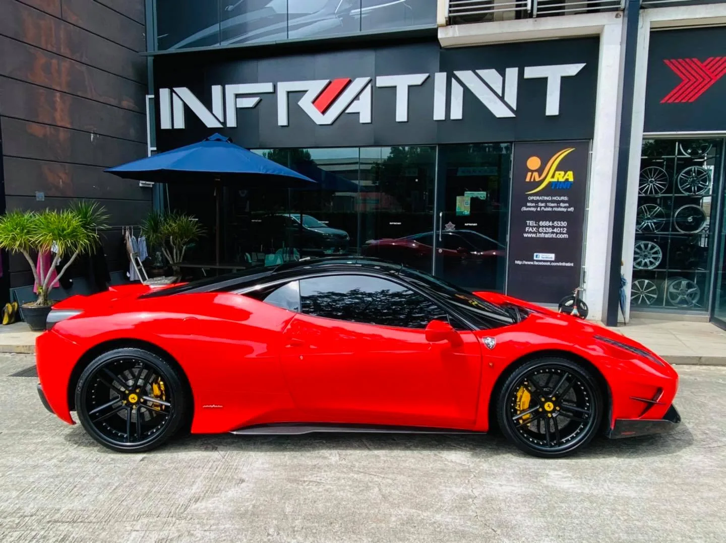 Red Ferrari side profile outside Infratint Singapore