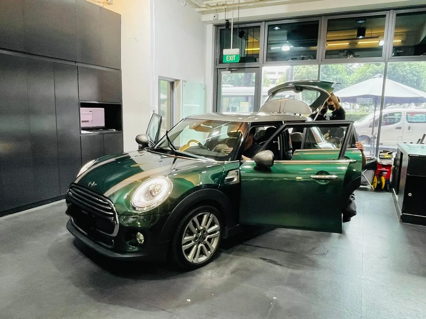 Green Mini Cooper with doors open during window film installation at Infratint Singapore