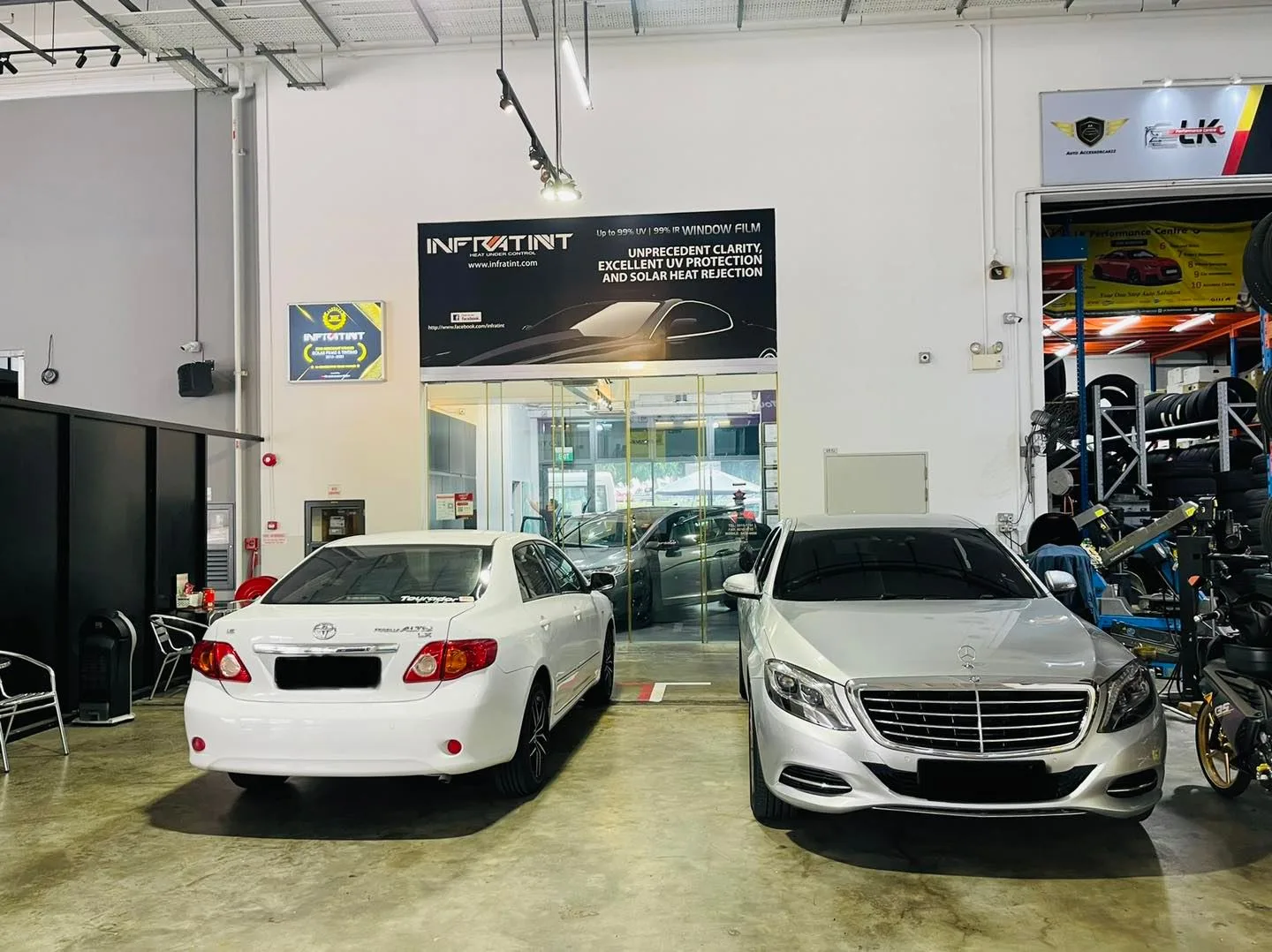 White Toyota sedan and silver Mercedes-Benz S-Class at Infratint Singapore install bay