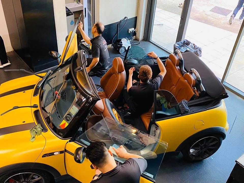 Overhead view of a yellow Mini Cooper convertible with tan interior being tinted at Infratint Singapore