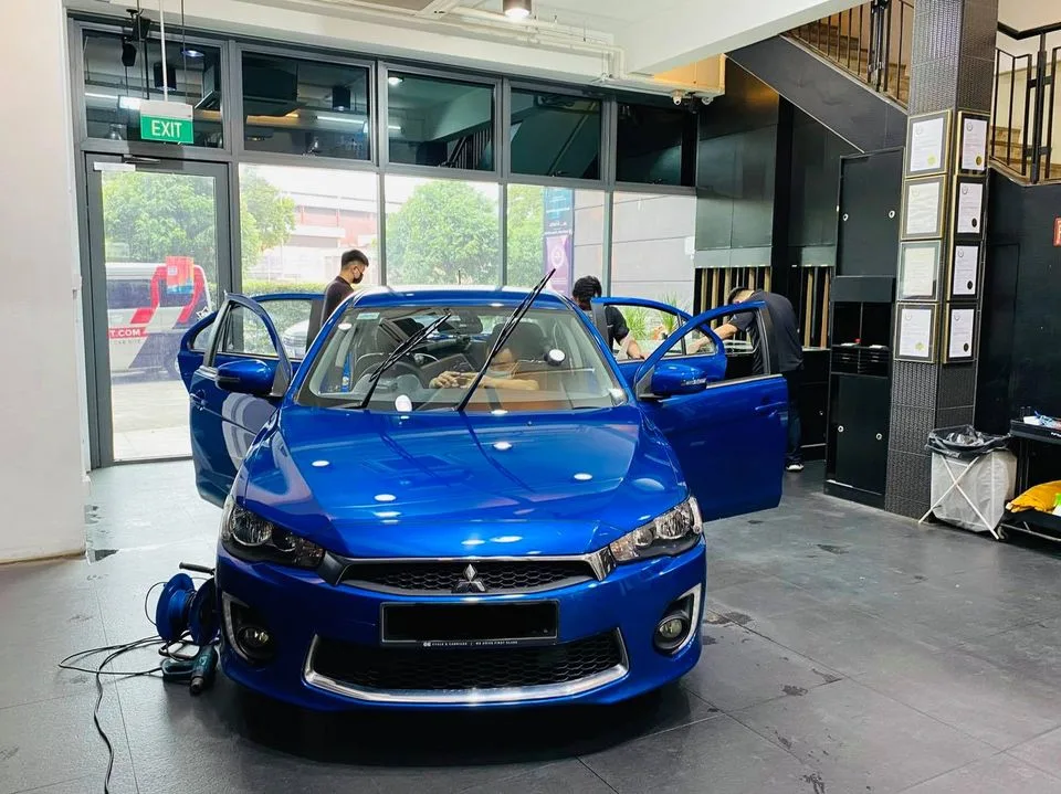 Blue Mitsubishi Lancer being prepped for window tinting at Infratint Singapore