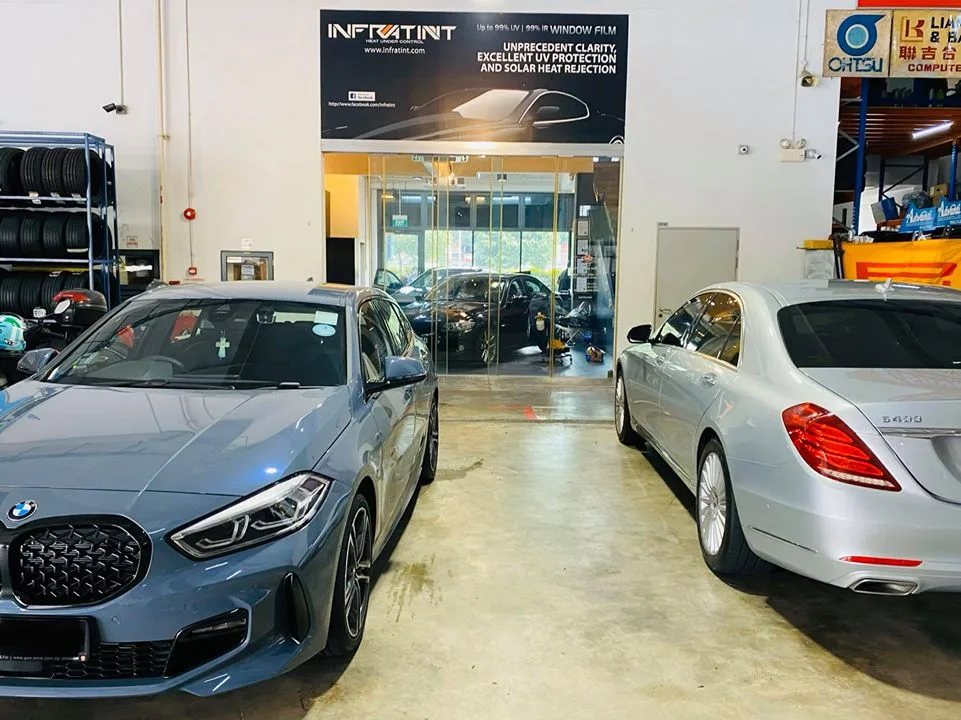 Blue-grey BMW 1 Series and silver Mercedes-Benz S400 parked in the Infratint Singapore workshop