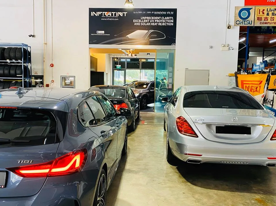 BMW 118i and silver Mercedes-Benz S400 parked rear-first in the Infratint Singapore bay