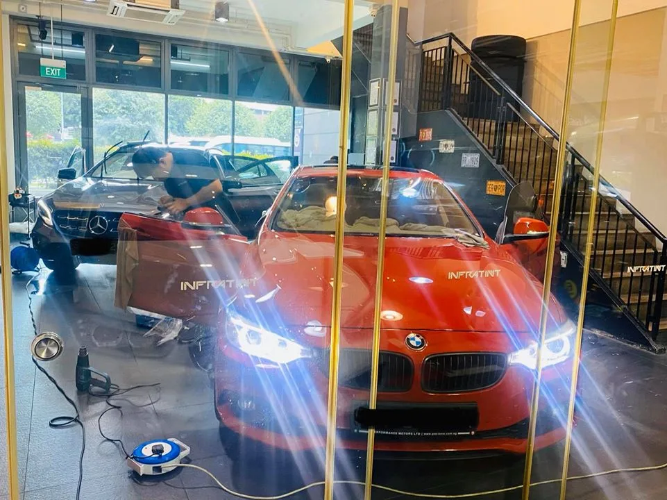 Copper BMW sedan and black Mercedes-Benz being window tinted at Infratint Singapore