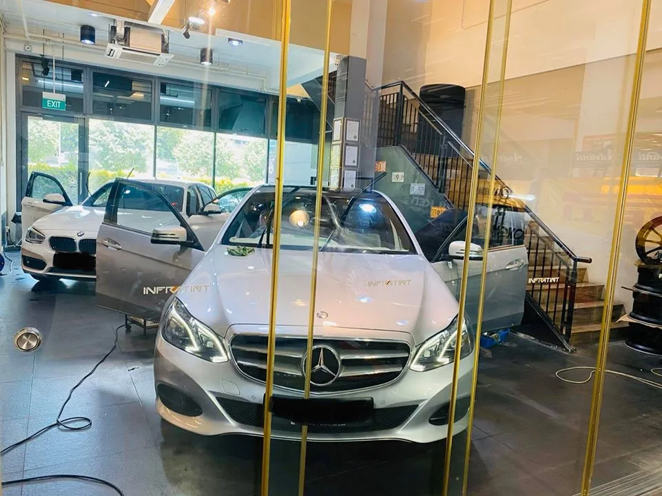 Silver Mercedes-Benz E-Class and white BMW hatch at Infratint Singapore during window tinting