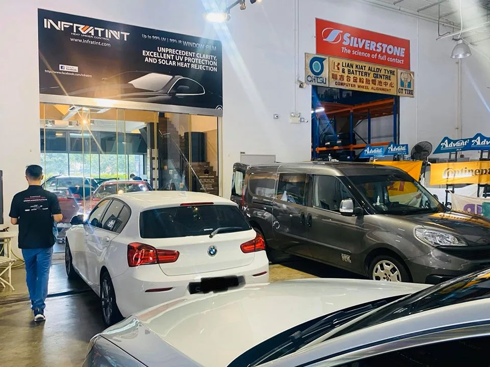 White BMW 1 Series and a grey van inside the Infratint Singapore workshop
