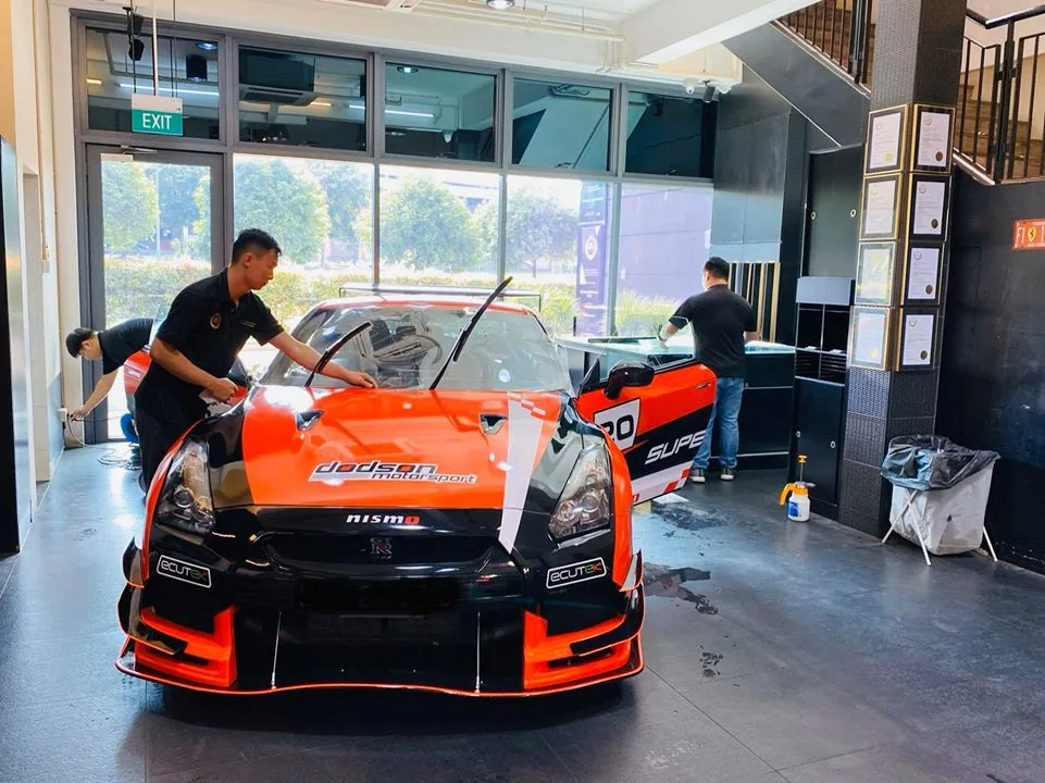 Orange race-liveried Nissan GT-R being prepped for window tinting at Infratint Singapore