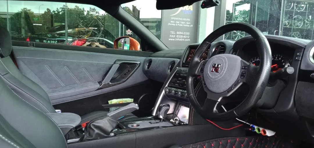 Nissan GT-R interior and steering wheel viewed through tinted glass at Infratint Singapore