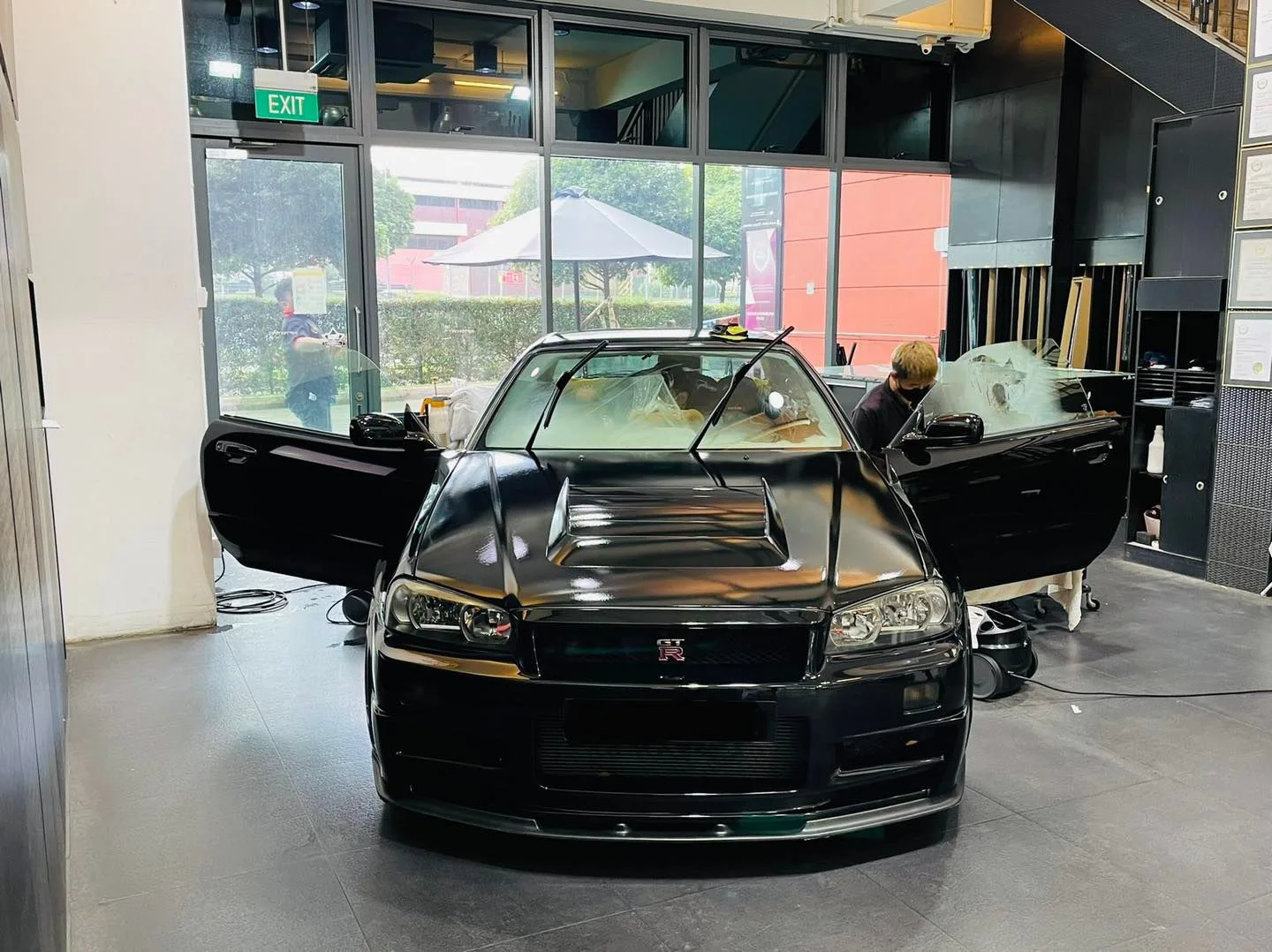 Black Nissan GT-R R34 with doors open during window tinting at Infratint Singapore