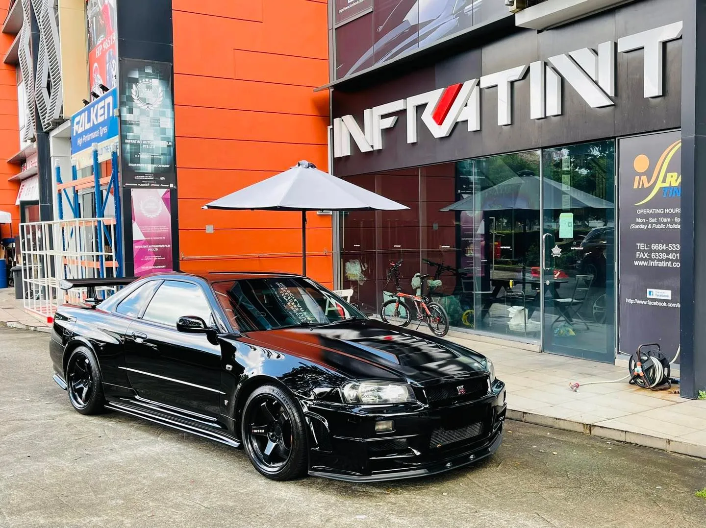 Black Nissan Skyline GT-R R34 outside the Infratint Singapore shopfront