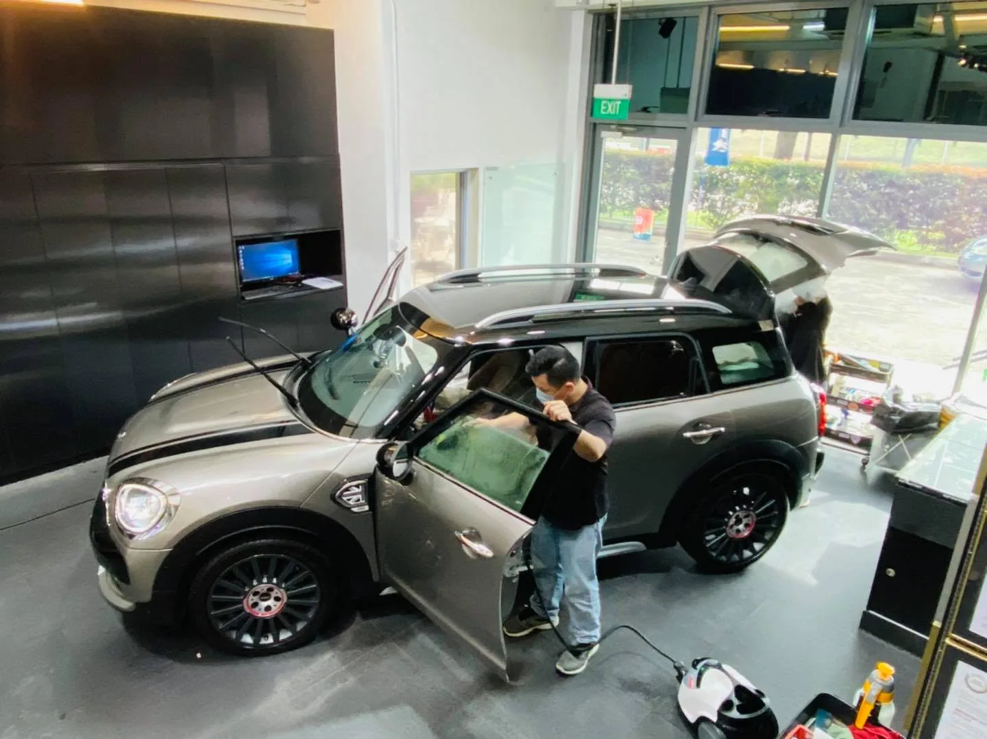 Installer applying window film to a grey Mini Countryman at Infratint Singapore