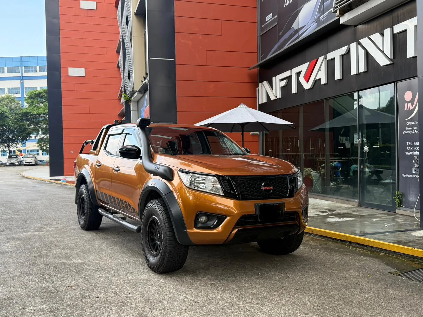 Orange Nissan Navara front three-quarter view outside Infratint Singapore