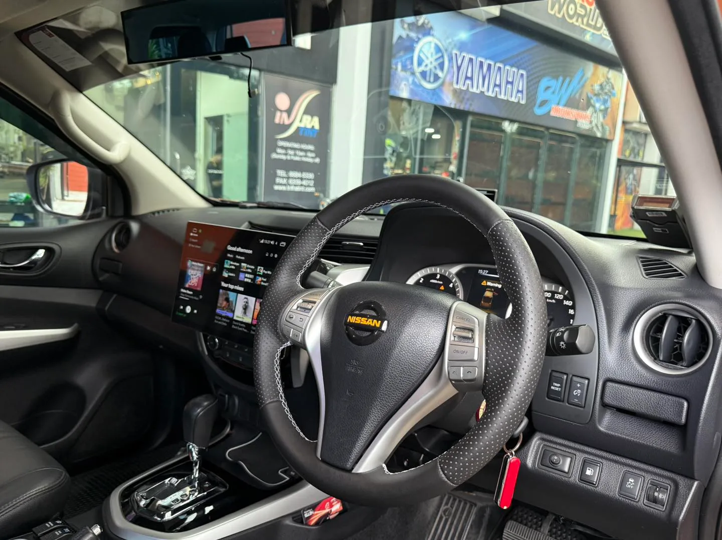 Nissan Navara interior steering wheel and touchscreen seen through tinted glass at Infratint Singapore