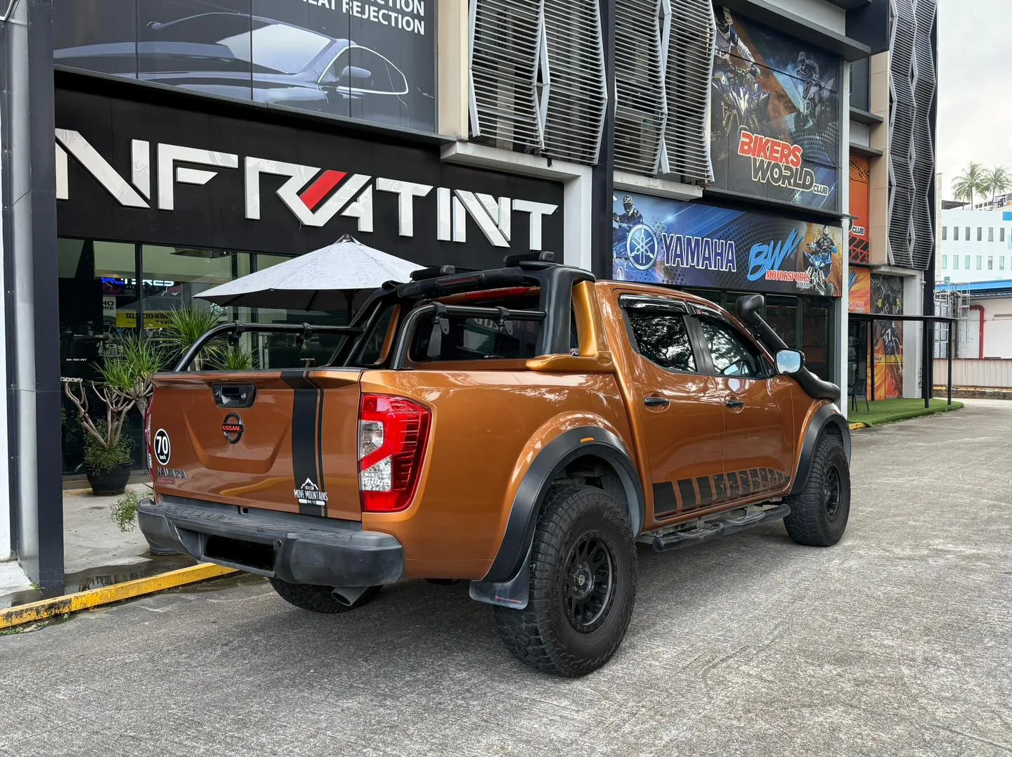 Orange Nissan Navara rear three-quarter view with tinted windows at Infratint Singapore