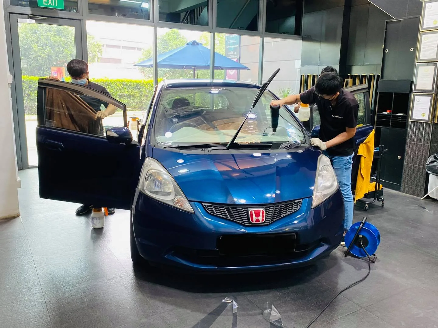 Blue Honda hatchback having its windscreen tinted at Infratint Singapore