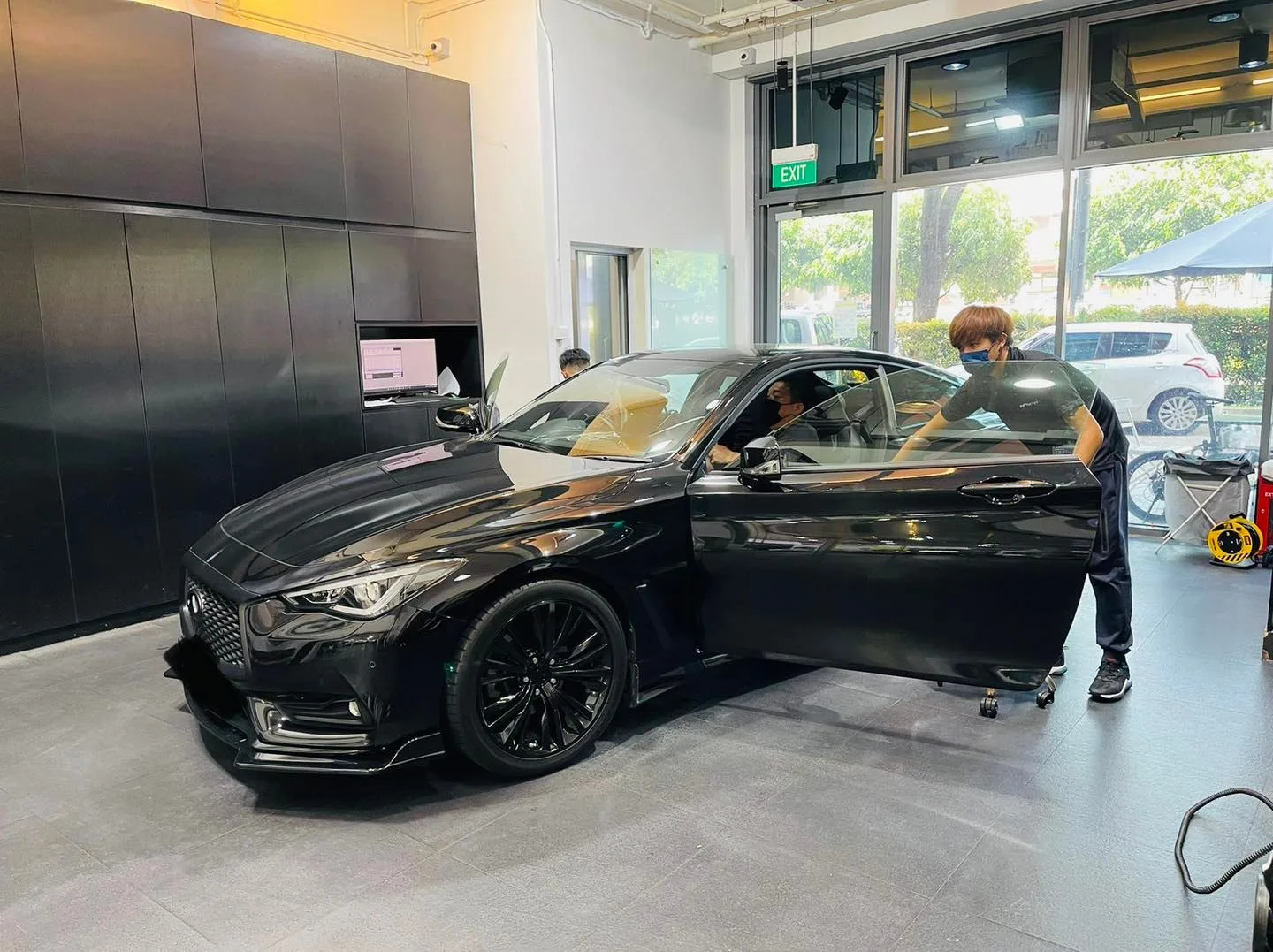 Black Infiniti Q60 coupe in three-quarter view during window tinting at Infratint Singapore
