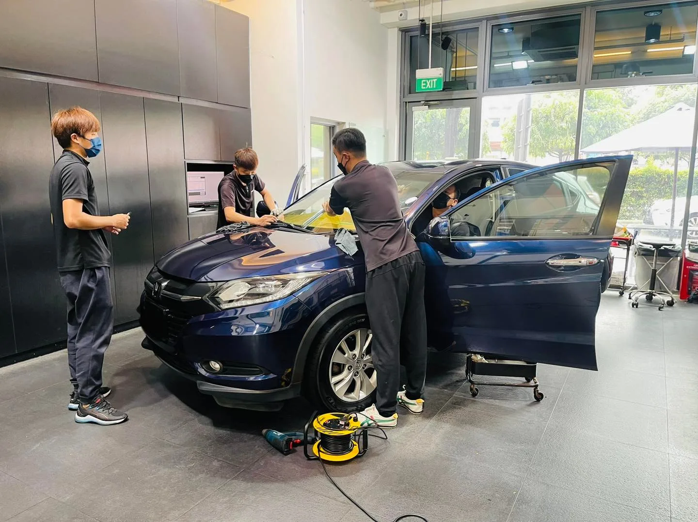 Dark blue Honda Vezel with door open during window film install at Infratint Singapore