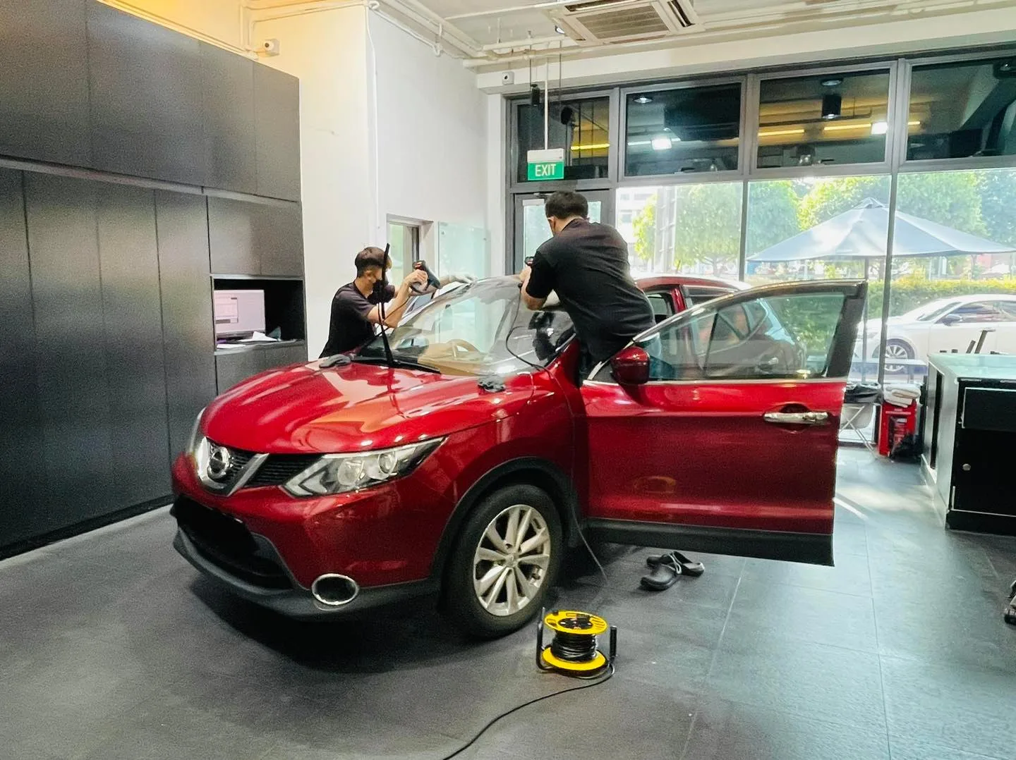Red Nissan Qashqai in three-quarter view during window tinting at Infratint Singapore