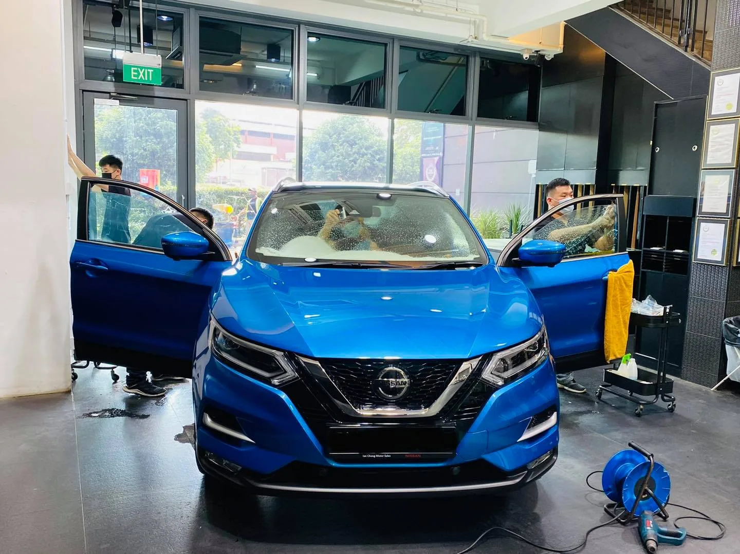 Blue Nissan Qashqai SUV with doors open during window tinting at Infratint Singapore