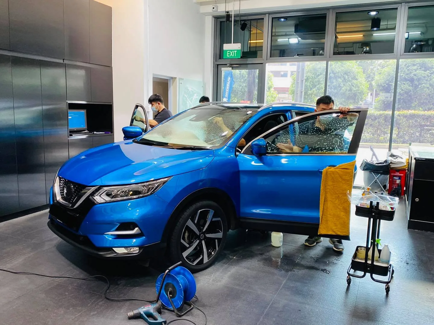 Blue Nissan Qashqai SUV getting window film fitted at Infratint Singapore