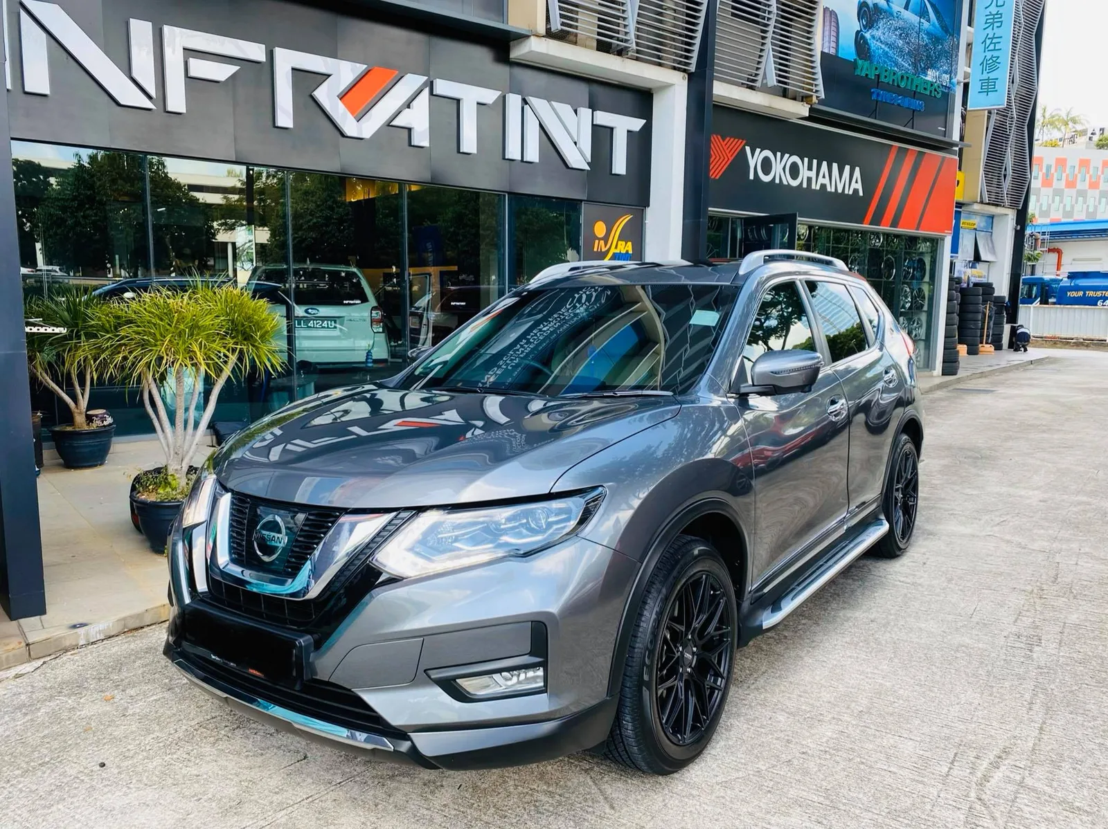 Grey Nissan X-Trail front three-quarter view outside Infratint Singapore