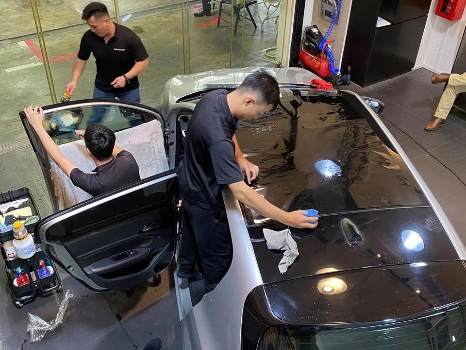 Technicians tinting the panoramic roof of a silver Peugeot 308 at Infratint Singapore