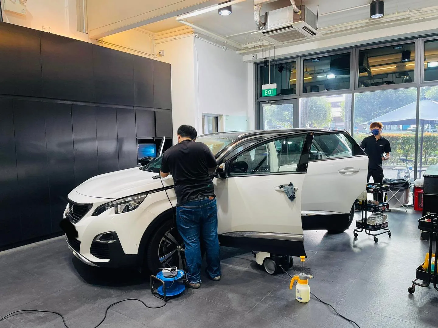 White Peugeot SUV during window film installation by two technicians at Infratint Singapore
