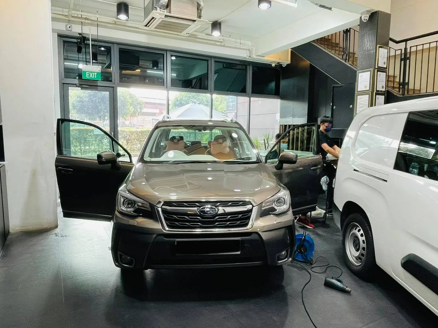 Bronze Subaru Forester and a white van inside the Infratint Singapore bay