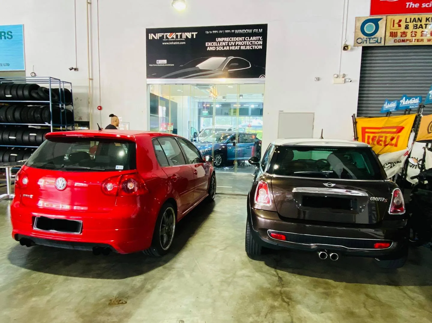 Red Volkswagen Golf GTI and brown Mini at Infratint Singapore awaiting window film