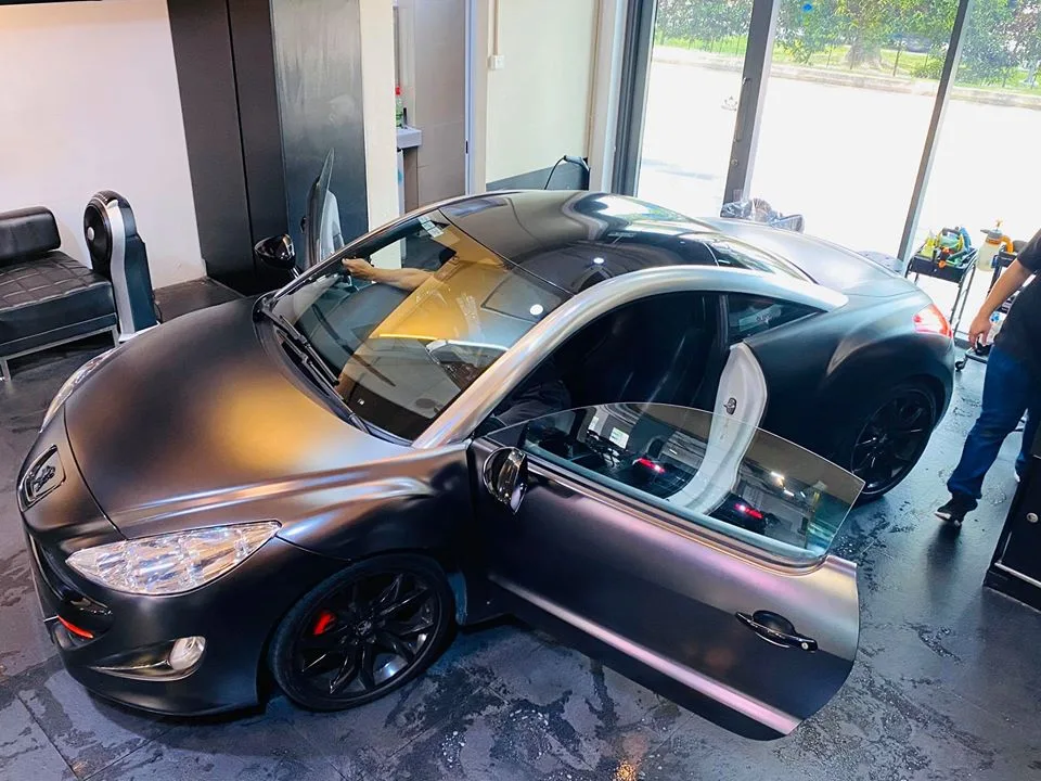 Elevated view of a matte Peugeot RCZ with tinted glass at Infratint Singapore
