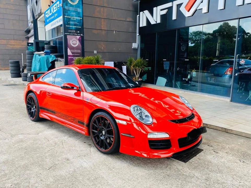 Red Porsche 911 parked outside Infratint Singapore after window tinting
