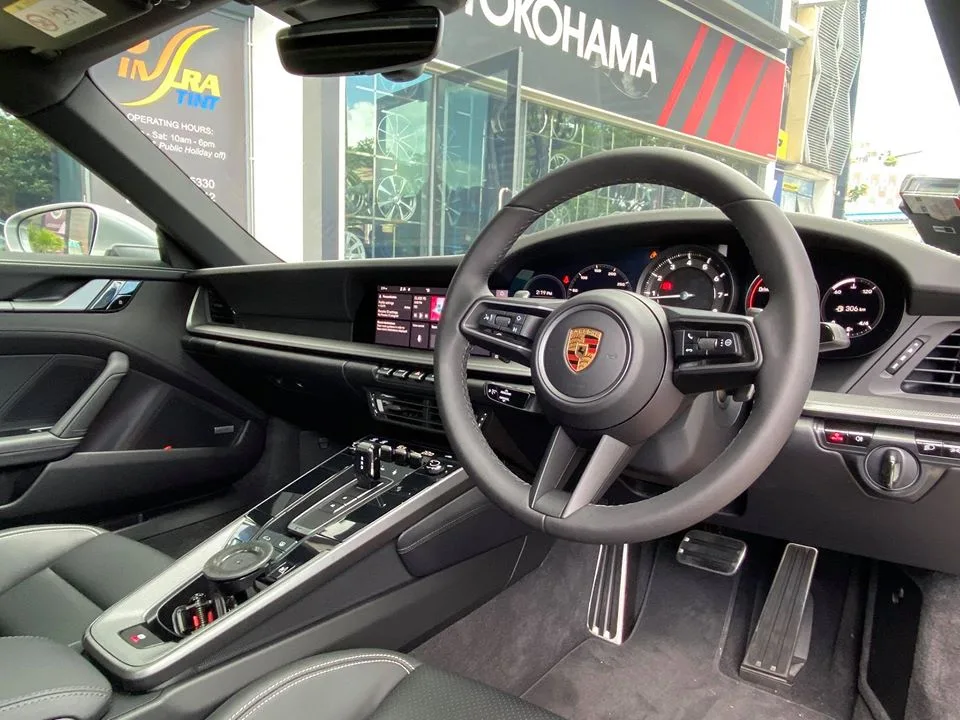 Interior steering wheel and gauges of a Porsche 911 Carrera 4S at Infratint Singapore